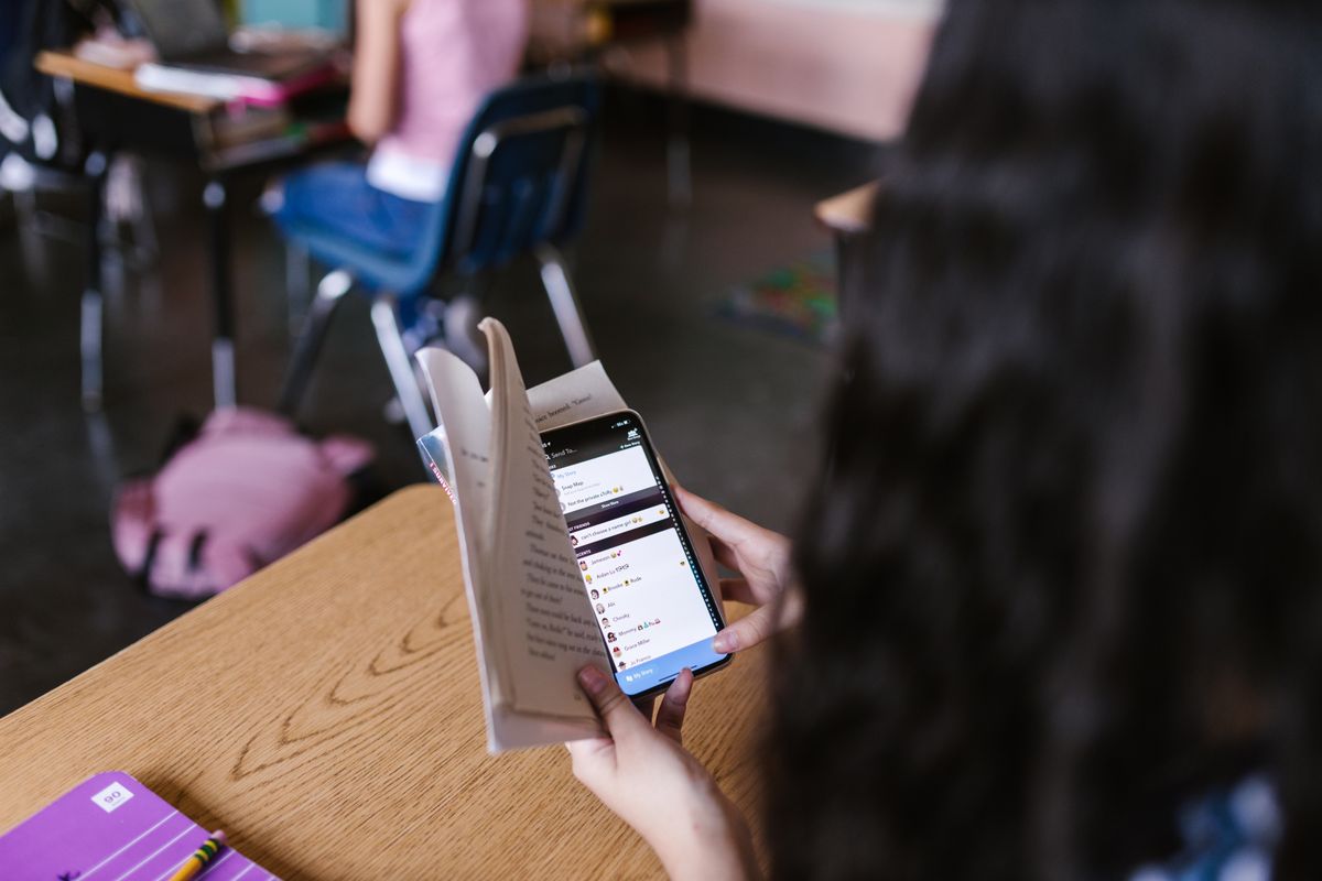Lycéen utilisant un smartphone en classe pendant un cours